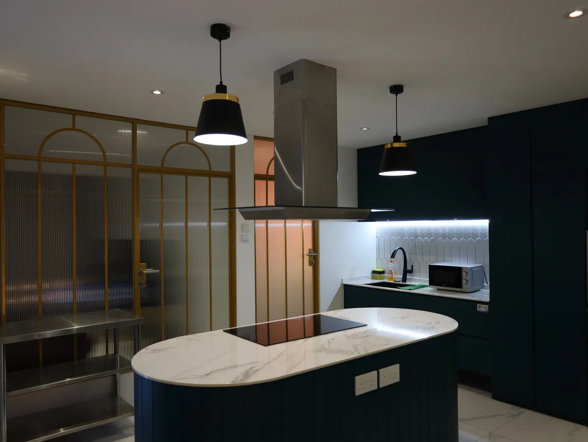 The Loft kitchen with marble island and gold-framed glass partition